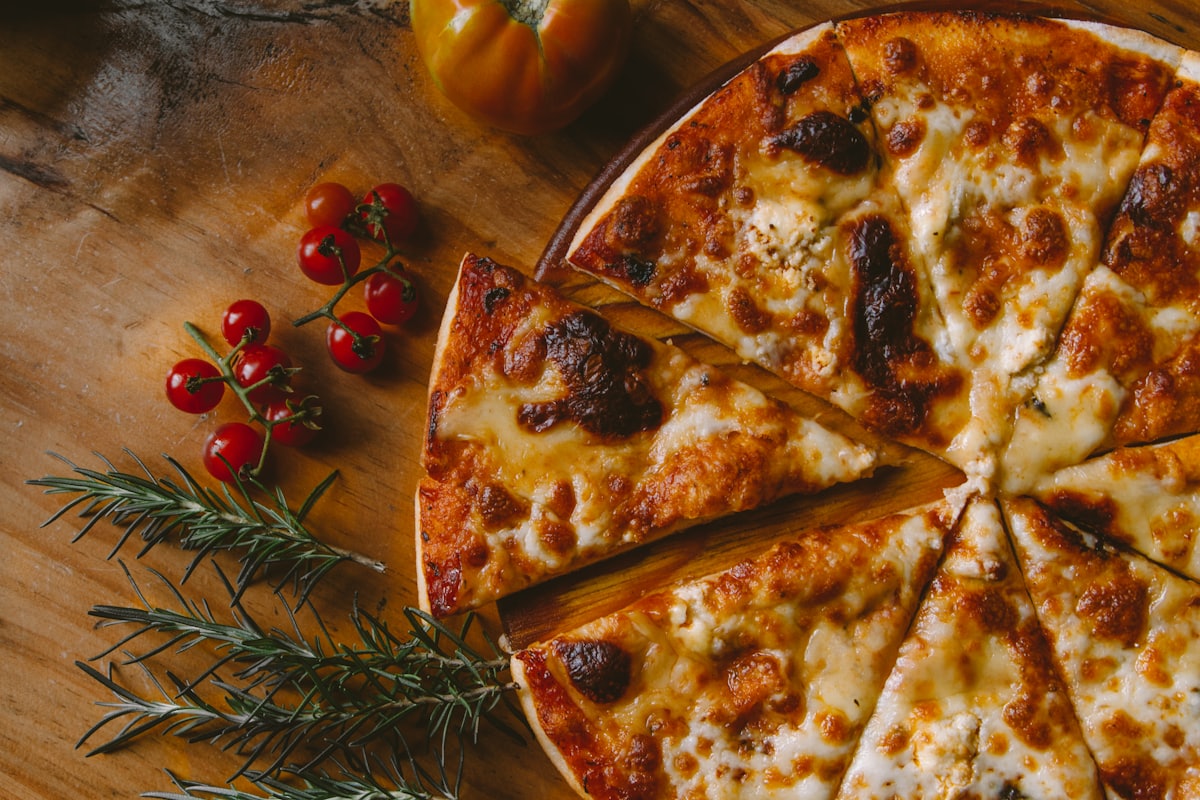 Pizza rústica com alecrim e tomate acabada de sair do forno a lenha